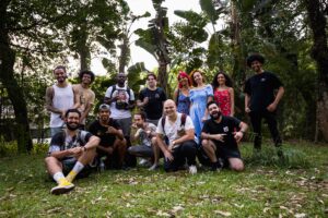 A diverse group posing happily together in a lush, outdoor setting.